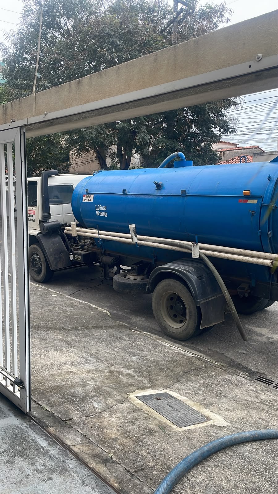Caminhão limpa-fossa azul da Poop Brothers em atendimento
